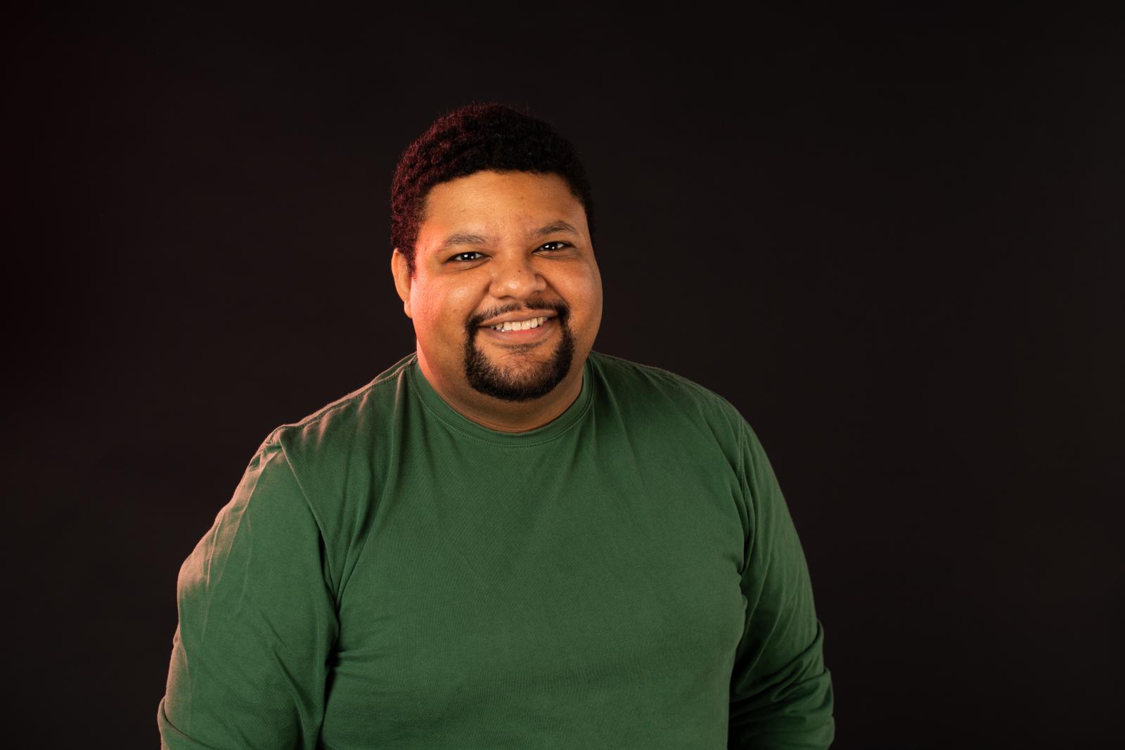 man in green shirt on black background