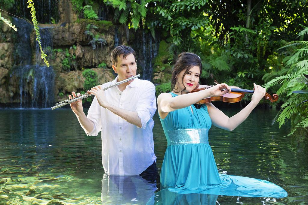man playing flute and woman playing violin in water