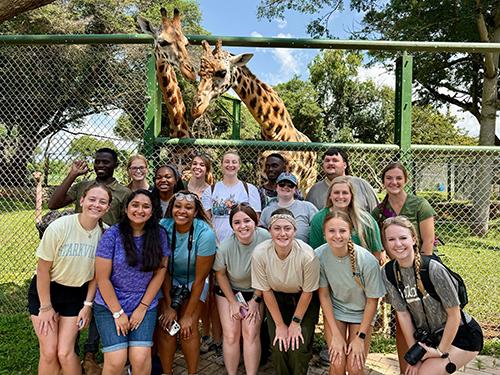 Faculty and students of Mississippi State’s College of Veterinary Medicine and Uganda’s Makerere University pose with giraffes.