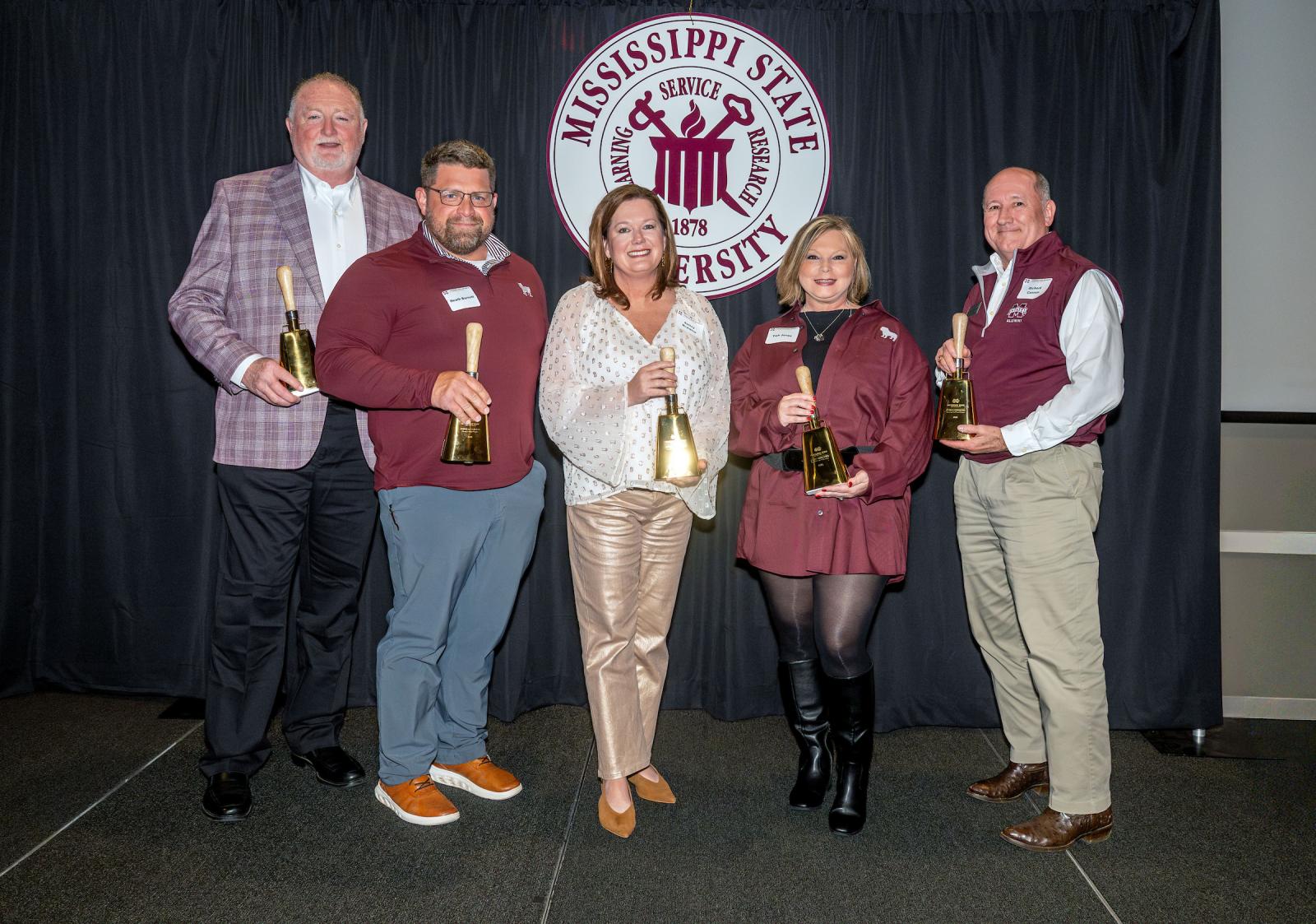 a group of award winners with golden cowbells