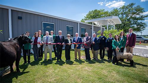 Flanked by 4-H and FFA students, cutting the ribbon on the new Livestock Evaluation Laboratory are Christy Bratcher, head, Department of Animal and Dairy Sciences; Keith Coble, Vice President, Division of Agriculture, Forestry and Veterinary Medicine, Mr. Brian Atkins, MSU alumnus and donor; U.S. Senator Cindy Hyde Smith; MSU President Mark Keenum, Scott Willard, Dean, College of Agriculture and Life Sciences and Interim Vice President for Research and Economic Development; and Darrell Sparks, acting dean.