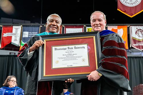 From left, retired U.S. Department of Agriculture Agricultural Research Service Southeast Director Archie Tucker receives an honorary Doctor of Public Service degree from Mississippi State President Mark E. Keenum.