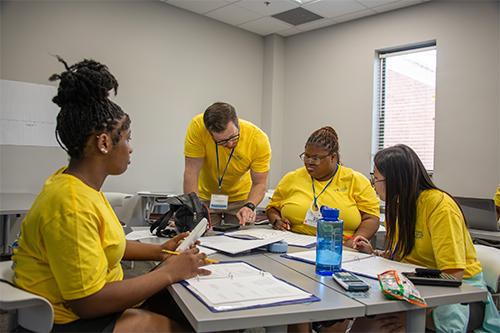 Global Teaching Project Supervisory Instructor Dane Peagler, center, a 2013 MSU physics graduate and Brandon High School science teacher, works with high school students visiting campus this week for the Advanced STEM Summer Preparatory Program, which introduces promising Mississippi public high school students to AP STEM courses.