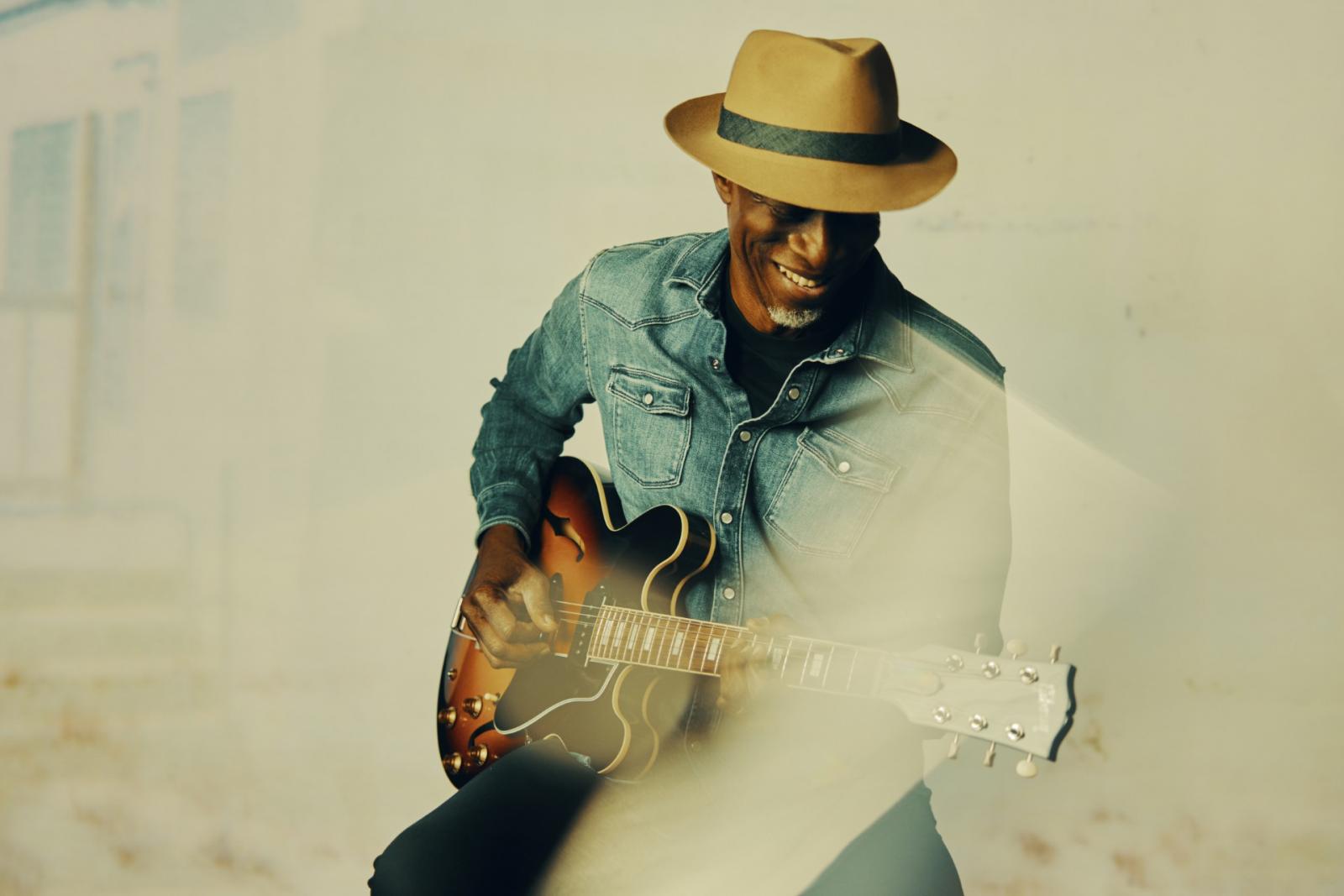 Photo of Keb' Mo' playing a guitar