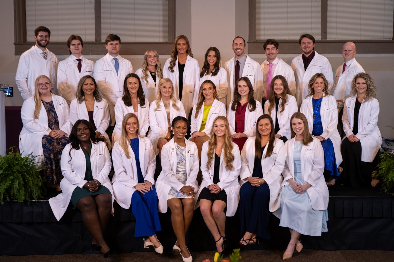 Photo of a group of MSU-Meridian physician assistant graduating class in white coats.