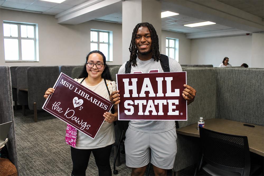 Raquel Mejia, a sophomore poultry science major from Myrtle, and Robert Moore, a landscape architecture sophomore from Hermitage, Tennessee, hold MSU school spirit signs this week during the welcome back event that unveiled the new fifth-floor space in MSU’s Mitchell Memorial Library.