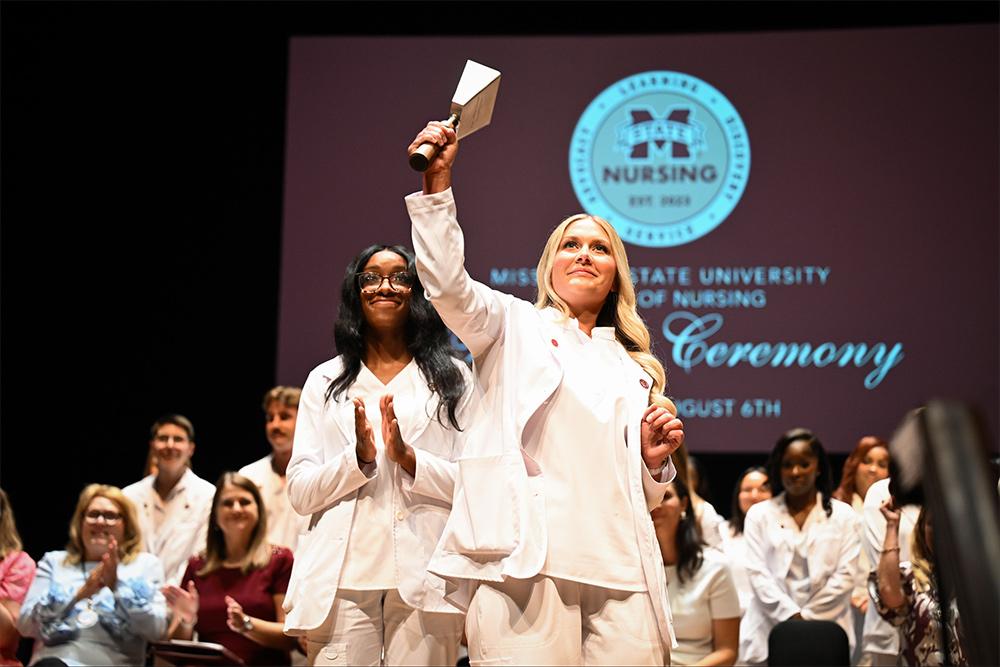 A student rings a cowbell during the Master of Science in Nursing graduation at the historic MSU Riley Center in downtown Meridian.