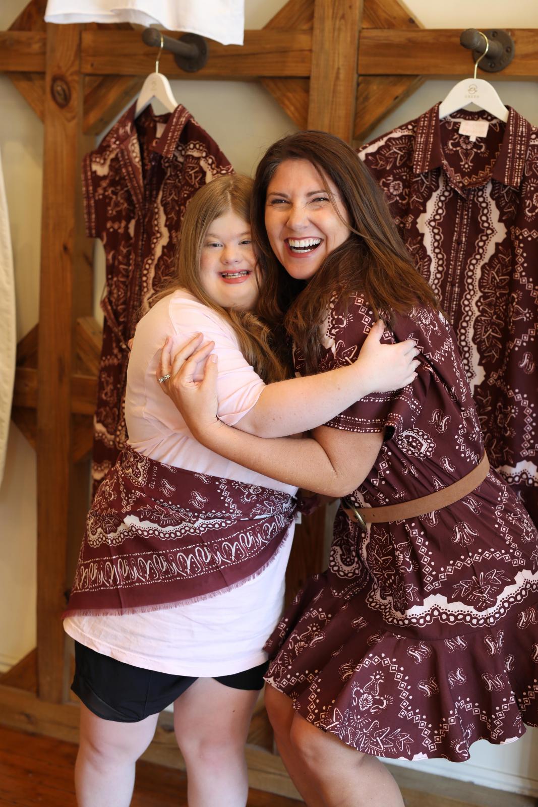 Allie Simmons celebrates with  her friend about her new dress design.