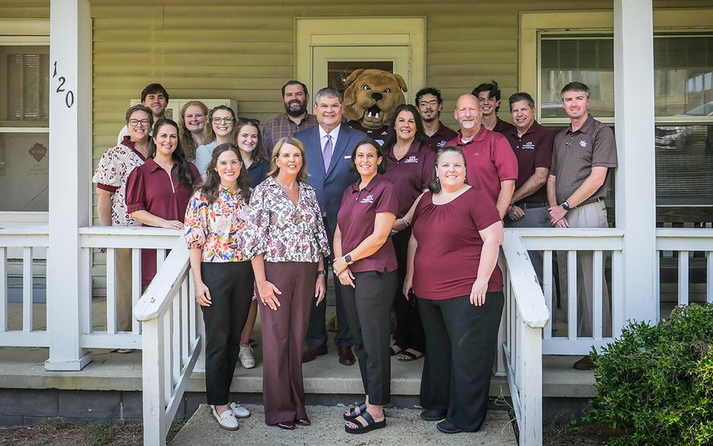 Mississippi State staff members pose outside of Bully's Pantry during a donation ceremony.