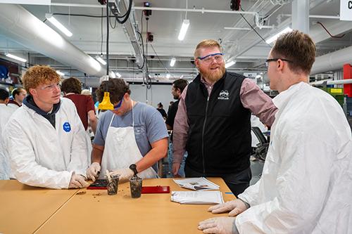 Mississippi State IDEELab Director Ross Smith, third from left, engages with ACE Composites participants as they work through a hands-on composite fabrication exercise, providing real-time guidance on material preparation, processing techniques and safe manufacturing practices.