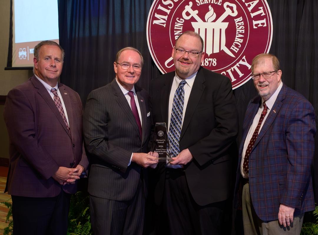 Photo of MSU VP and president with award winner Michael Nadorff